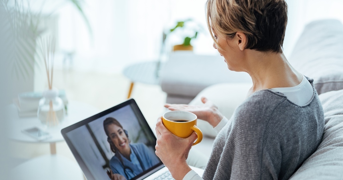 Woman interacting with healthcare professional via laptop  Woman interacting with healthcare professional via laptop