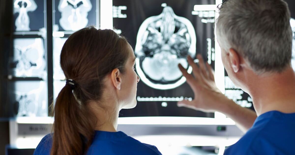 Clinicians inspecting an MRI scan Clinicians inspecting an MRI scan