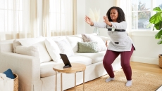A woman wearing Hinge sensors performing exercises guided via a tablet A woman wearing Hinge sensors performing exercises guided via a tablet