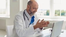Doctor sitting at a desk looking at a computer