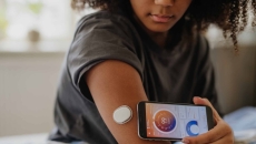 Woman with a CGM and smart phone Woman with a CGM and smart phone