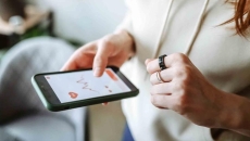 Person with a smart ring looking at an app on their mobile phone Person with a smart ring looking at an app on their mobile phone