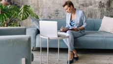 Person sitting on a couch while looking at a computer