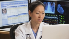 Healthcare professional reviewing patient data on a PC Healthcare professional reviewing patient data on a PC
