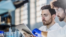 Two researchers looking at a tablet computer  Two researchers looking at a tablet computer