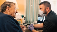 An Atrium Health community paramedic consults with patient in his home. An Atrium Health community paramedic consults with patient in his home.