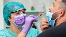Healthcare worker testing a patient for COVID