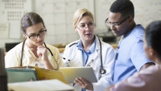 Healthcare professionals reviewing patient chart on a tablet computer Healthcare professionals reviewing patient chart on a tablet computer