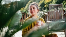 Person sitting outside while drinking a cup of coffee Person sitting outside while drinking a cup of coffee