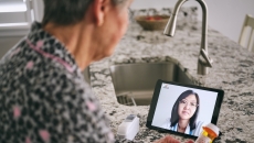 Person interacting with healthcare professional via tablet Person interacting with healthcare professional via tablet