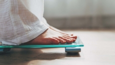 Person's feet standing on a scale Person's feet standing on a scale