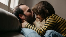 Father and son on a couch playing Father and son on a couch playing