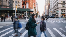 People walking across a crosswalk in the streets of a large city People walking across a crosswalk in the streets of a large city