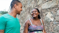 Two people walking together while looking at each other and smiling Two people walking together while looking at each other and smiling
