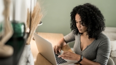Person sitting at a desk while looking at a computer Person sitting at a desk while looking at a computer