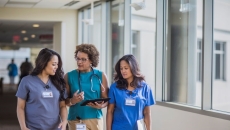 three people walking together three people walking together in a hospital