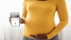 A pregnant women holding a smartphone with the PALS app A pregnant women holding a smartphone with the PALS app