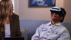 Patient using a Rendever headset while sitting next to another individual Patient using a Rendever headset while sitting next to another individual