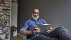 Person sitting in a chair while looking at a tablet Person sitting in a chair while looking at a tablet