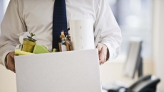 A worker holding a box of his belongings. A worker holding a box of his belongings.