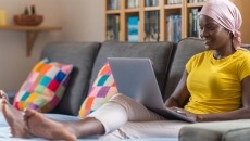 Person using laptop on a couch Person using laptop on a couch