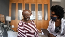 A cancer patient talking to a provider in her home. A cancer patient talking to a provider in her home.