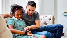 A child setting up a smartwatch with a parent A child setting up a smartwatch with a parent