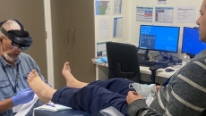 A clinician demonstrating the use of mixed-reality glasses for remote assessment of a foot wound