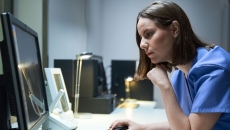 A doctor looking at a MRI results on a desktop computer A doctor looking at a MRI results on a desktop computer