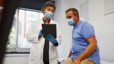 A medical professional showing a patient information on a tablet