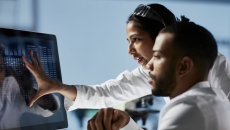 Doctors looking at patient data on a monitor Doctors looking at patient data on a monitor