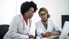 Two doctors looking at data on a laptop Two doctors looking at data on a laptop