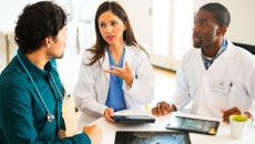 Doctors talking together with digital tablets and X-rays. Doctors talking together with digital tablets and X-rays.