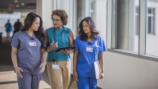 Three healthcare professionals conversing Three healthcare professionals conversing