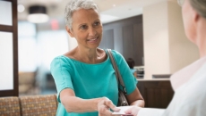 Person handing insurance card to a healthcare worker