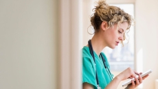 A nurse using her smartphone. A nurse using her smartphone.