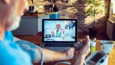 Patient taking their blood pressure while on a video call with a provider Patient taking their blood pressure while on a video call with a provider