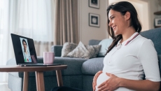 A pregnant person talking to a provider through a video chat on her laptop. A pregnant person talking to a provider through a video chat on her laptop.
