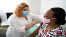 A healthcare provider administering a vaccine. A healthcare provider administering a vaccine.