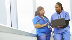 A doctor showing his colleague information on a laptop A doctor showing his colleague information on a laptop
