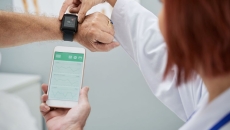 Doctor showing senior patient how to synchronize health app in smartphone and smartwatch Doctor showing senior patient how to synchronize health app in smartphone and smartwatch