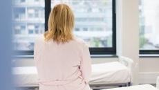 A photo of a woman sitting on a hospital bed A photo of a woman sitting on a hospital bed