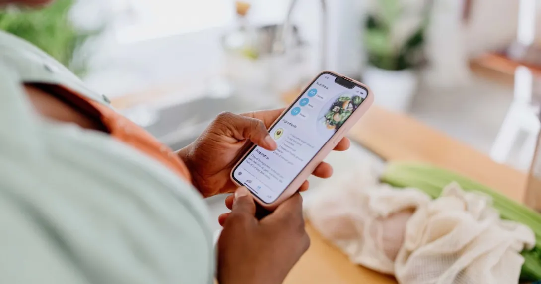 Person looking at a health app on their phone Person looking at a health app on their phone