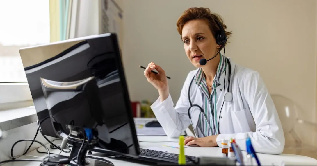 A doctor uses headphones with a mic in a call  A doctor uses headphones with a mic in a call