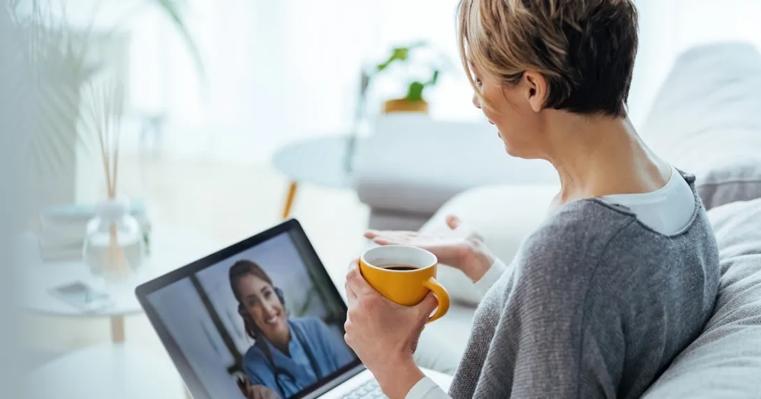 Woman interacting with healthcare professional via laptop  Woman interacting with healthcare professional via laptop