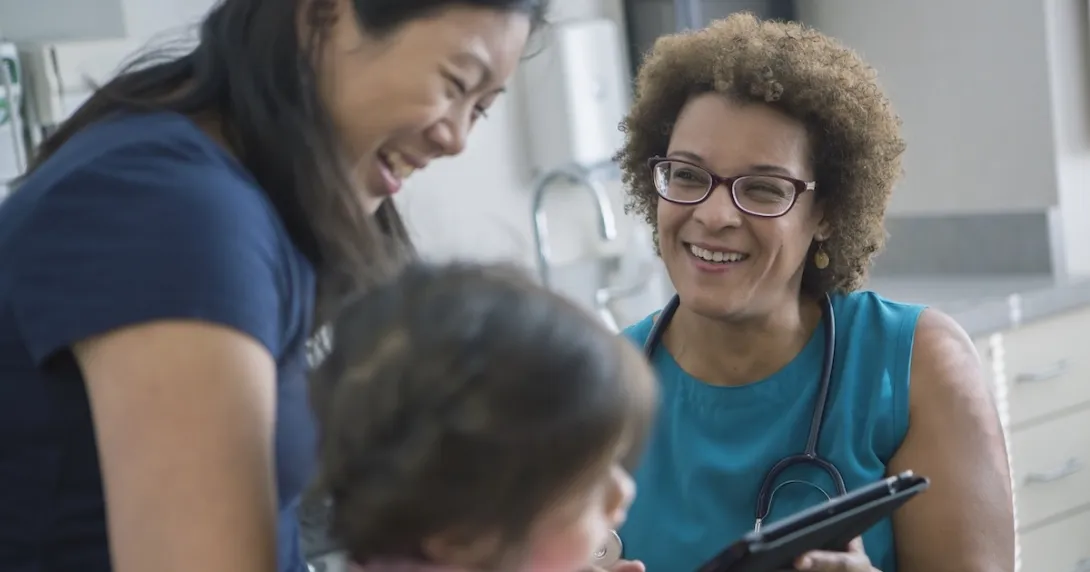 A woman and child talking to a healthcare professional A woman and child talking to a healthcare professional