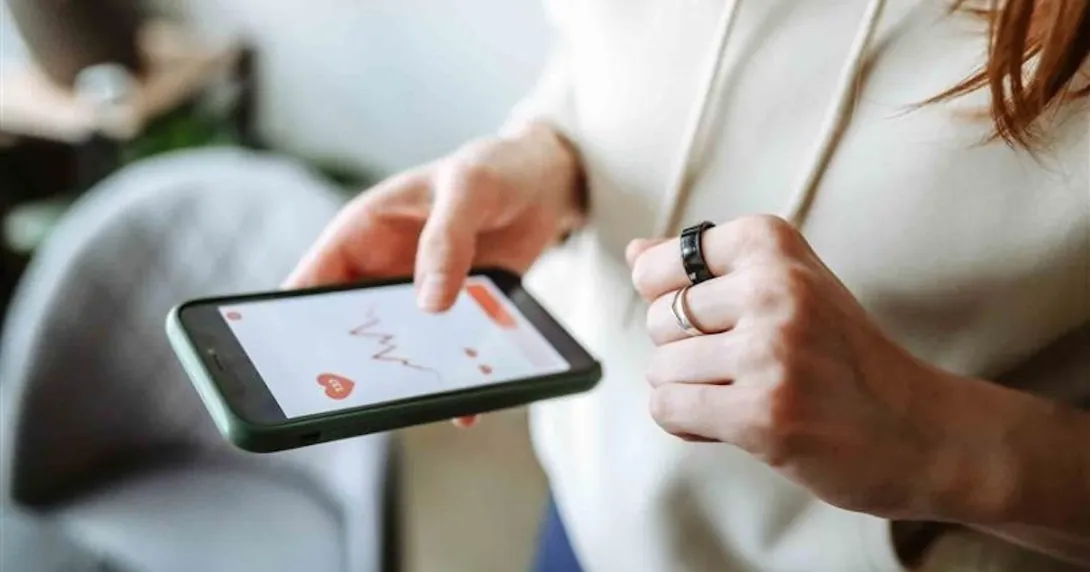 Person with a smart ring looking at an app on their mobile phone Person with a smart ring looking at an app on their mobile phone