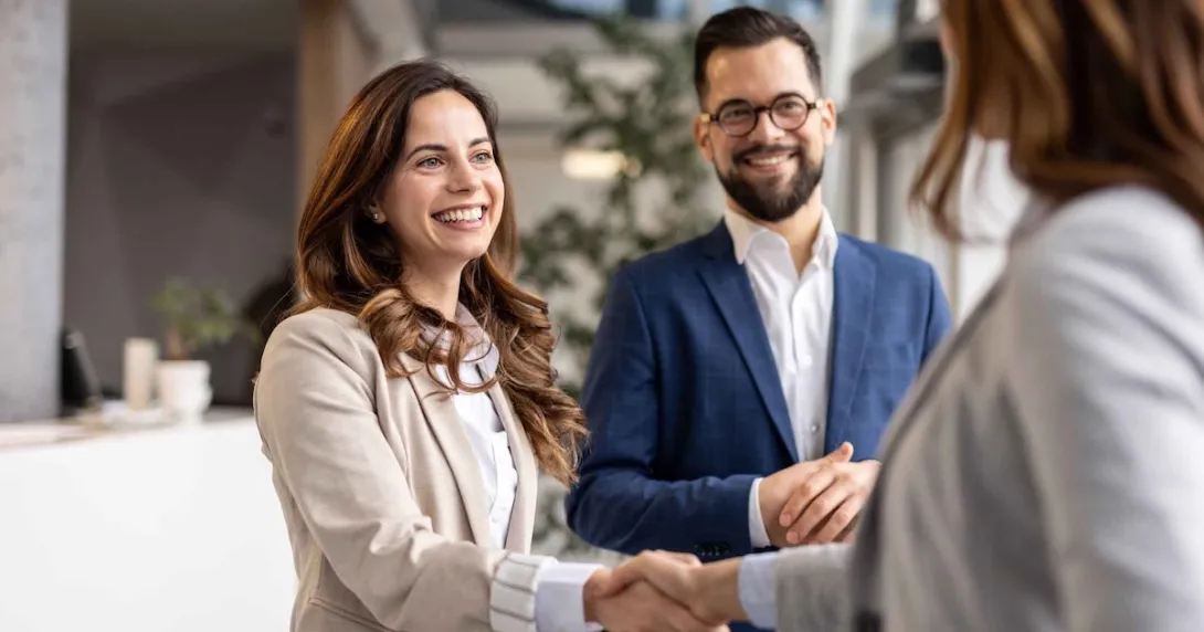 Businesswomen shaking hands during a meeting with a businessman Businesswomen shaking hands during a meeting with a businessman