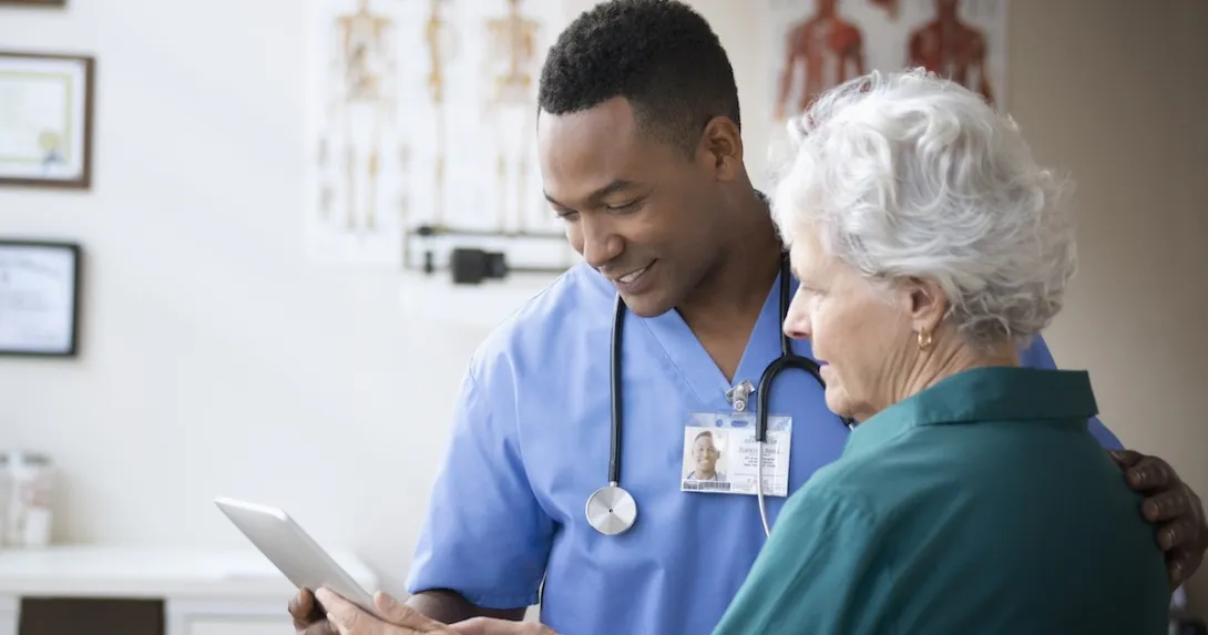 Health care team member reviewing medical history with patient Health care team member reviewing medical history with patient