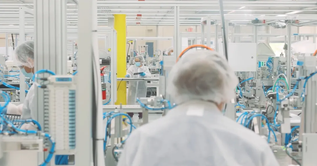 Workers in a Cue Health manufacturing facility Workers in a Cue Health manufacturing facility